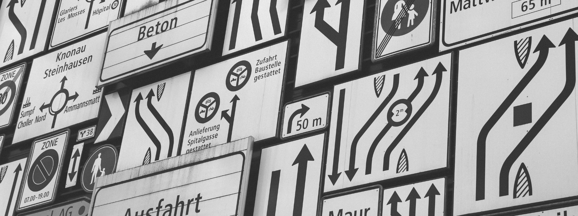 black and white signposts with lots of arrows pointing in different directions