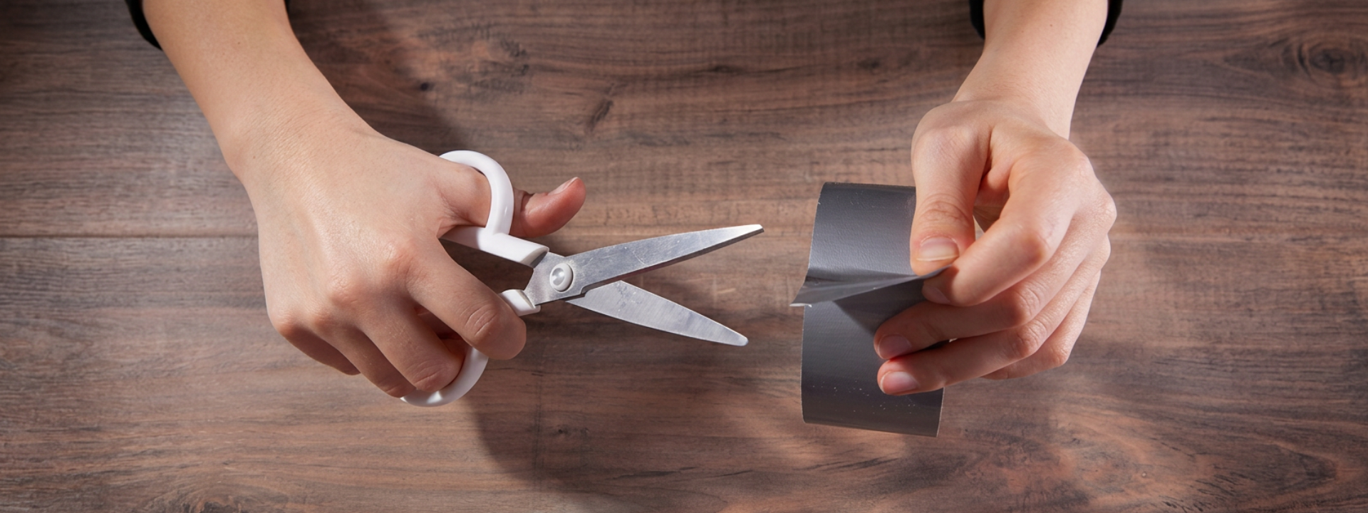 two white hands holding a scissors and duct tape to represent how global brands cobble together their global marketing set-ups