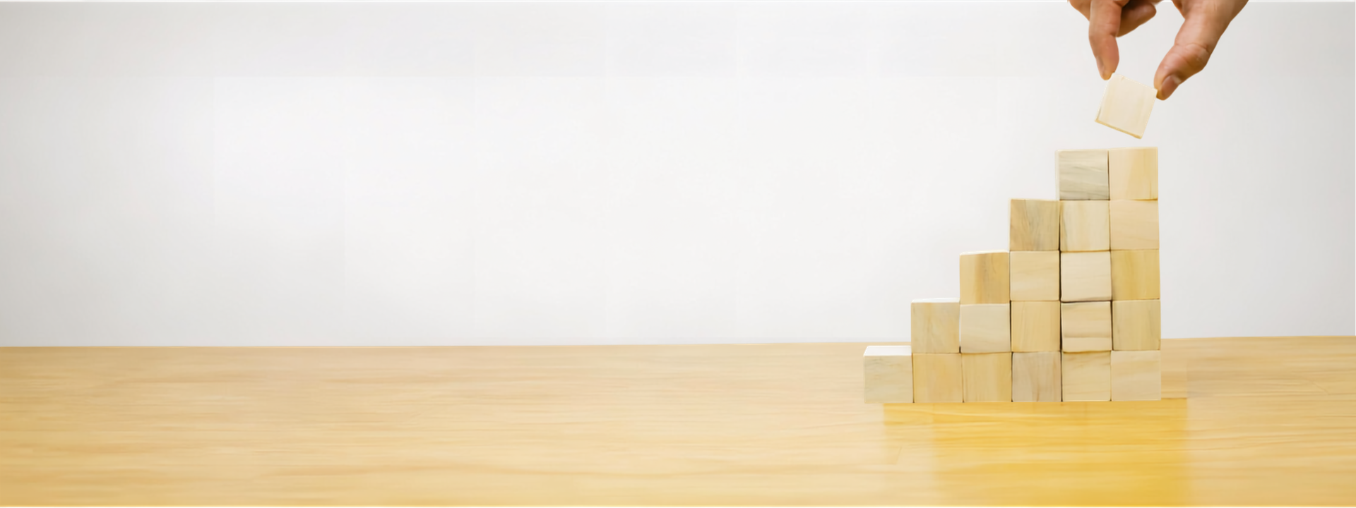 a pile of wooden blocks with a block being added representing growth
